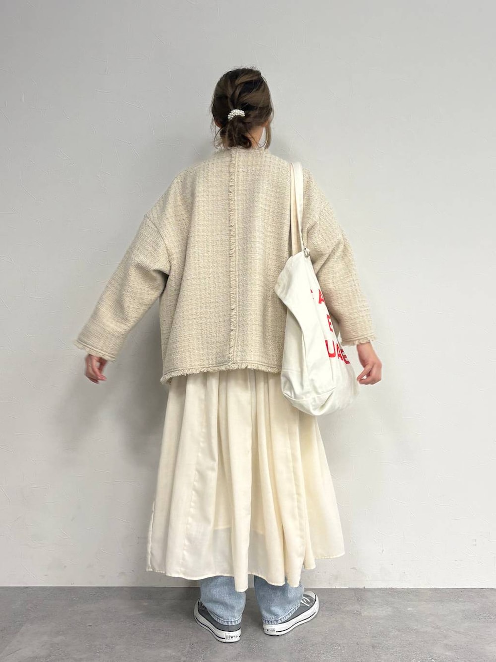 ブルー系のデニムパンツ、ベージュ系のスカート、ベージュ系のノーカラージャケットを着用したレディースの冬コーディネートの5枚目の写真