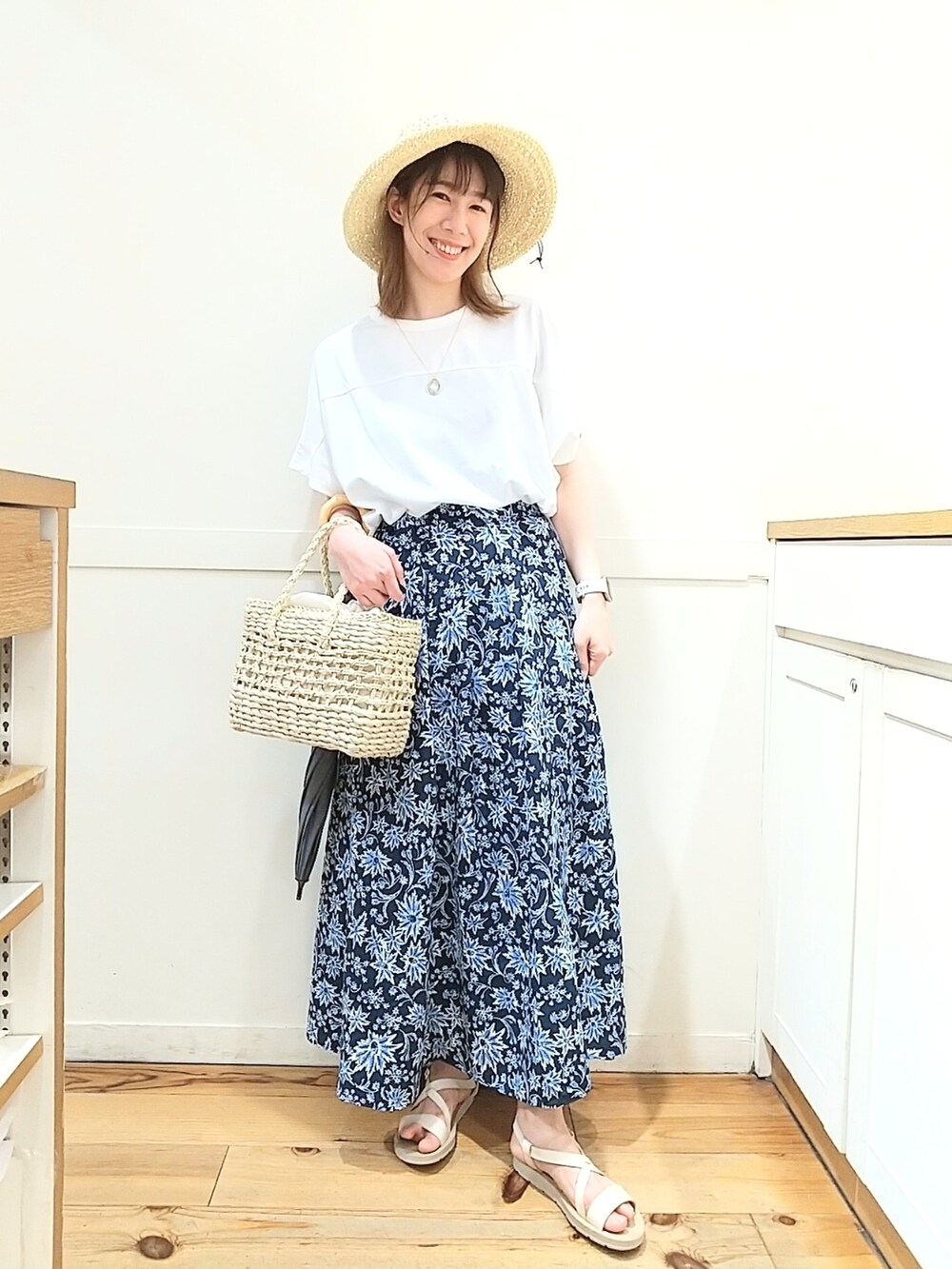 ホワイト系のTシャツ/カットソー、ホワイト系のかごバッグ、ブルー系のスカートを着用したレディースの春コーディネートの2枚目の写真