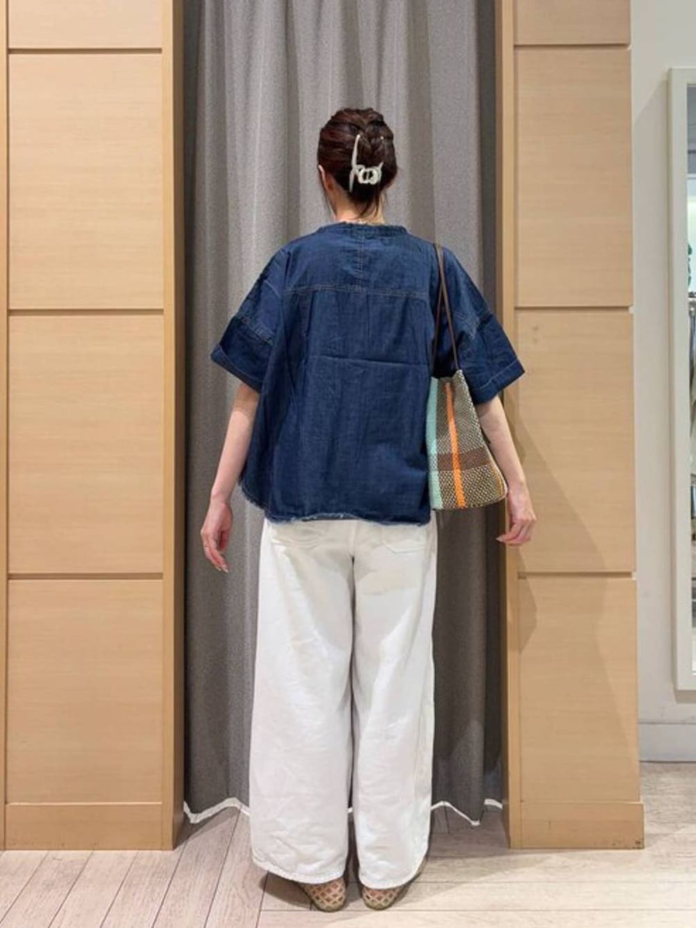 ブラウン系のトートバッグ、ブラック系のタンクトップ、ベージュ系のパンプスを着用したレディースの夏コーディネートの2枚目の写真