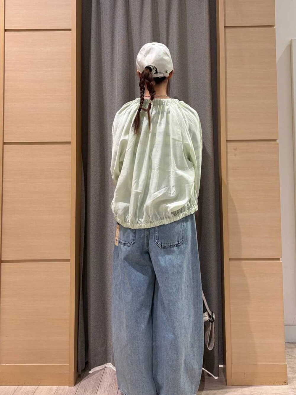 ブルー系のデニムパンツ、ベージュ系のショルダーバッグ、その他のニット/セーターを着用したレディースの春コーディネートの5枚目の写真