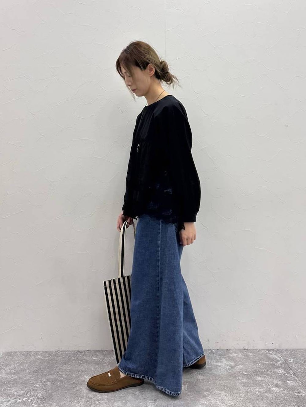 ブルー系のデニムパンツ、イエロー系のローファー、イエロー系のトートバッグを着用したレディースの春コーディネートの4枚目の写真