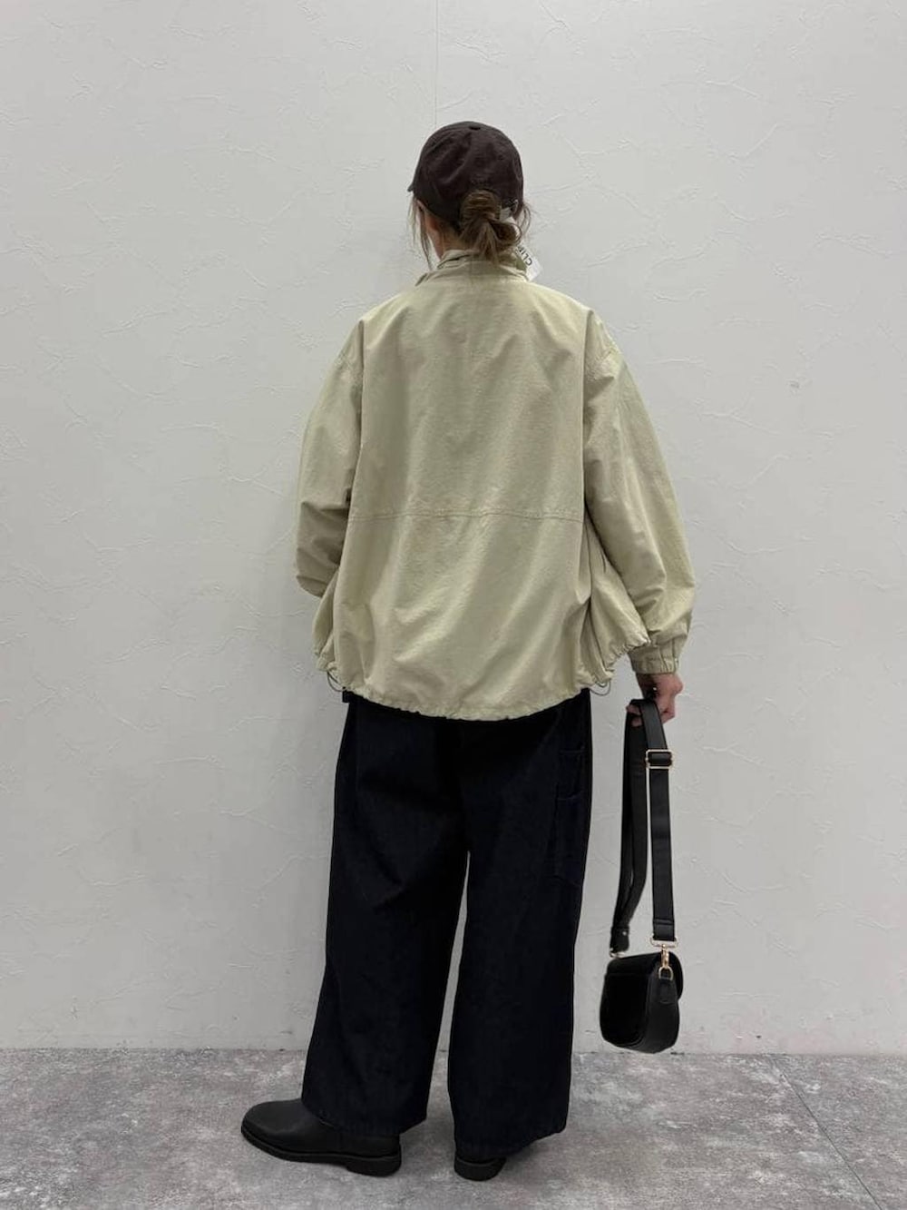 ブラック系のスリッポン、ブラック系のショルダーバッグ、ブルー系のその他パンツを着用したレディースの春コーディネートの4枚目の写真