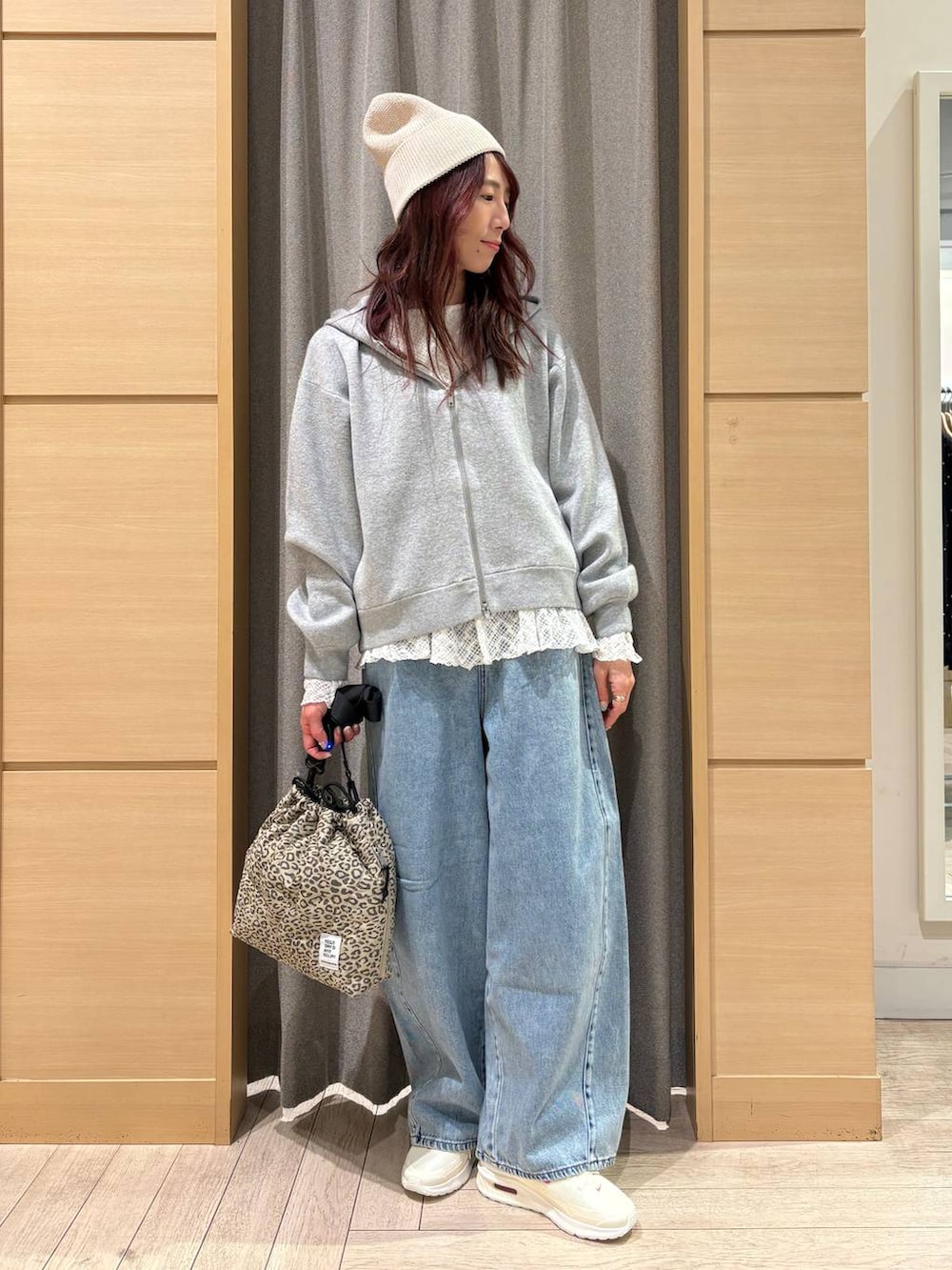 ブルー系のデニムパンツ、ベージュ系のショルダーバッグ、ホワイト系のTシャツ/カットソーを着用したレディースの春コーディネートの3枚目の写真