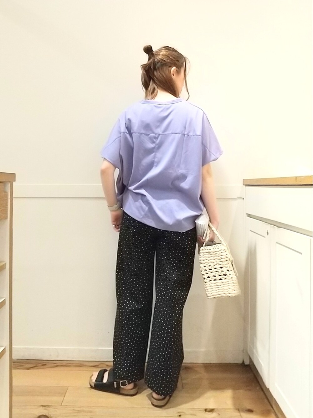 ブラック系のサンダル、ブラウン系のかごバッグ、ブルー系のTシャツ/カットソーを着用したレディースの春コーディネートの3枚目の写真