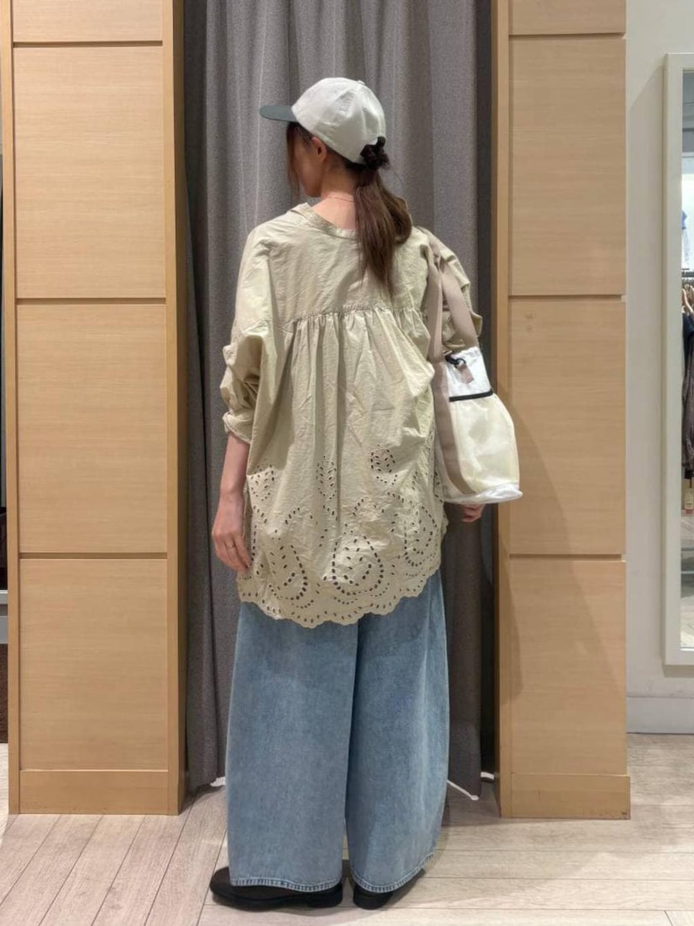 ブラウン系のベスト、ブルー系のデニムパンツ、ブラウン系のスリッポンを着用したレディースの春コーディネートの4枚目の写真