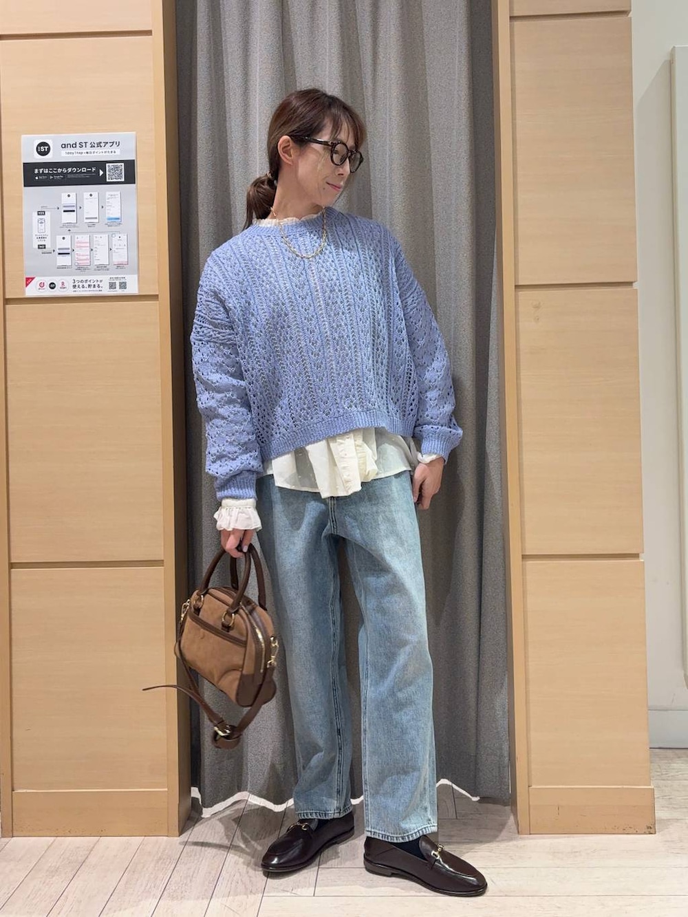 ブルー系のデニムパンツ、ブラウン系のショルダーバッグ、ホワイト系のシャツ/ブラウスを着用したレディースの春コーディネートの4枚目の写真