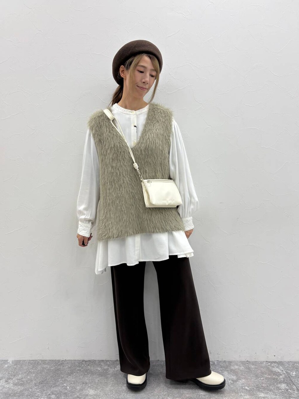 ホワイト系のシャツ/ブラウス、ベージュ系のブーツ、ブラウン系のその他パンツを着用したレディースの秋コーディネートの2枚目の写真