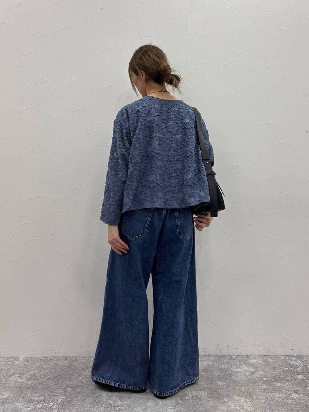 ブラック系のTシャツ/カットソー、ブルー系のデニムパンツ、ブラック系のローファーを着用したレディースの春コーディネートの3枚目の写真