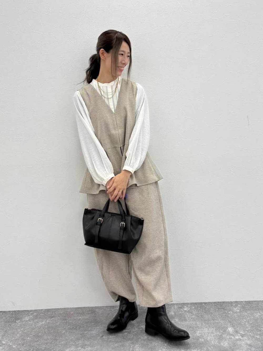 ホワイト系のシャツ/ブラウス、ブラック系のブーツ、ブラック系のショルダーバッグを着用したレディースの冬コーディネートの3枚目の写真