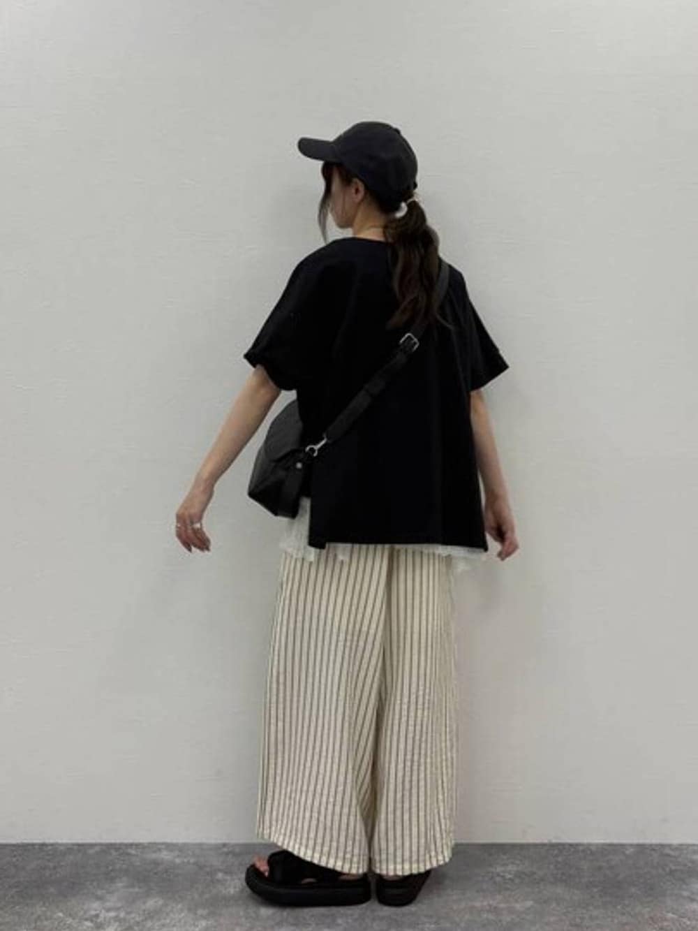 ブラック系のサンダル、ブラック系のTシャツ/カットソー、ブラック系のショルダーバッグを着用したレディースの夏コーディネートの2枚目の写真