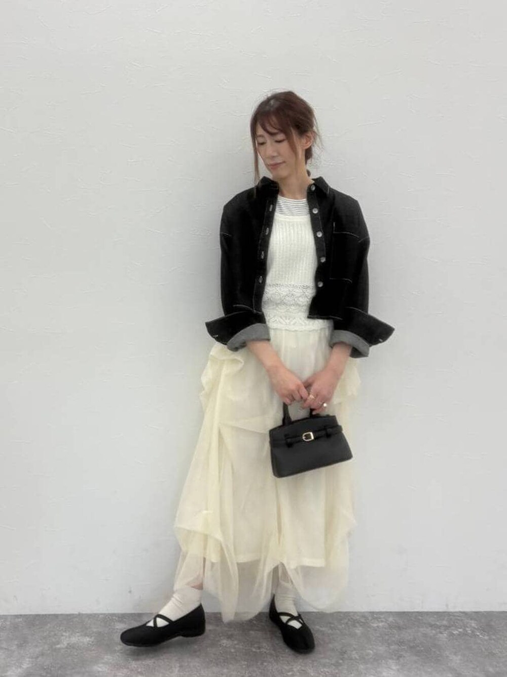 ブラック系のショルダーバッグ、ブラック系のバレエシューズ、ブラック系のデニムジャケットを着用したレディースの春コーディネートの4枚目の写真