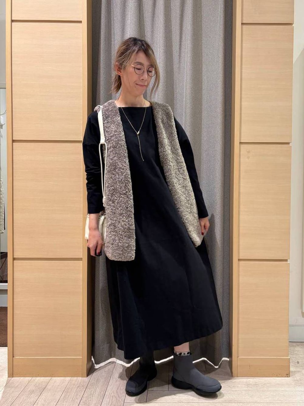 その他のベスト、グレー系のブーツ、ブラック系のショルダーバッグを着用したレディースの秋コーディネートの6枚目の写真