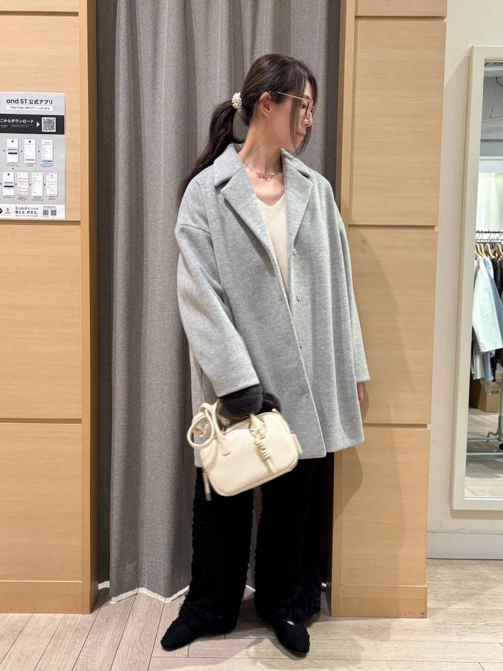 ブラック系のパンプス、ベージュ系のトートバッグ、グレー系のチェスターコートを着用したレディースの冬コーディネートの2枚目の写真