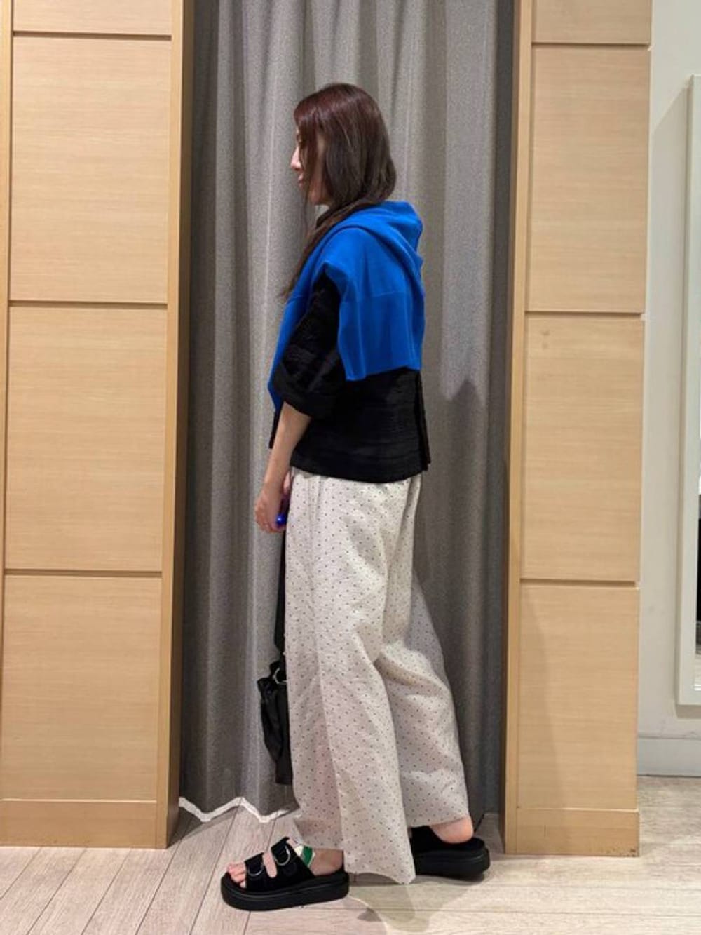 ブルー系のカーディガン/ボレロ、ブラック系のサンダル、ベージュ系のトートバッグを着用したレディースの春コーディネートの3枚目の写真