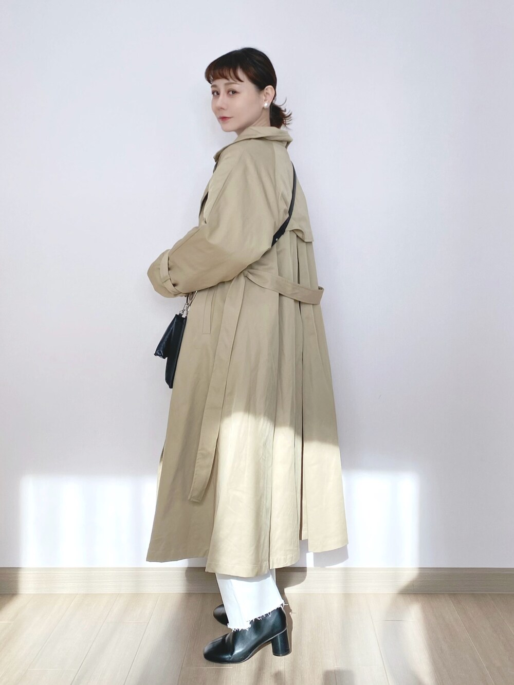 ベージュ系のミリタリージャケット、ブラック系のニット/セーター、ブラック系のショルダーバッグを着用したレディースの冬コーディネートの4枚目の写真