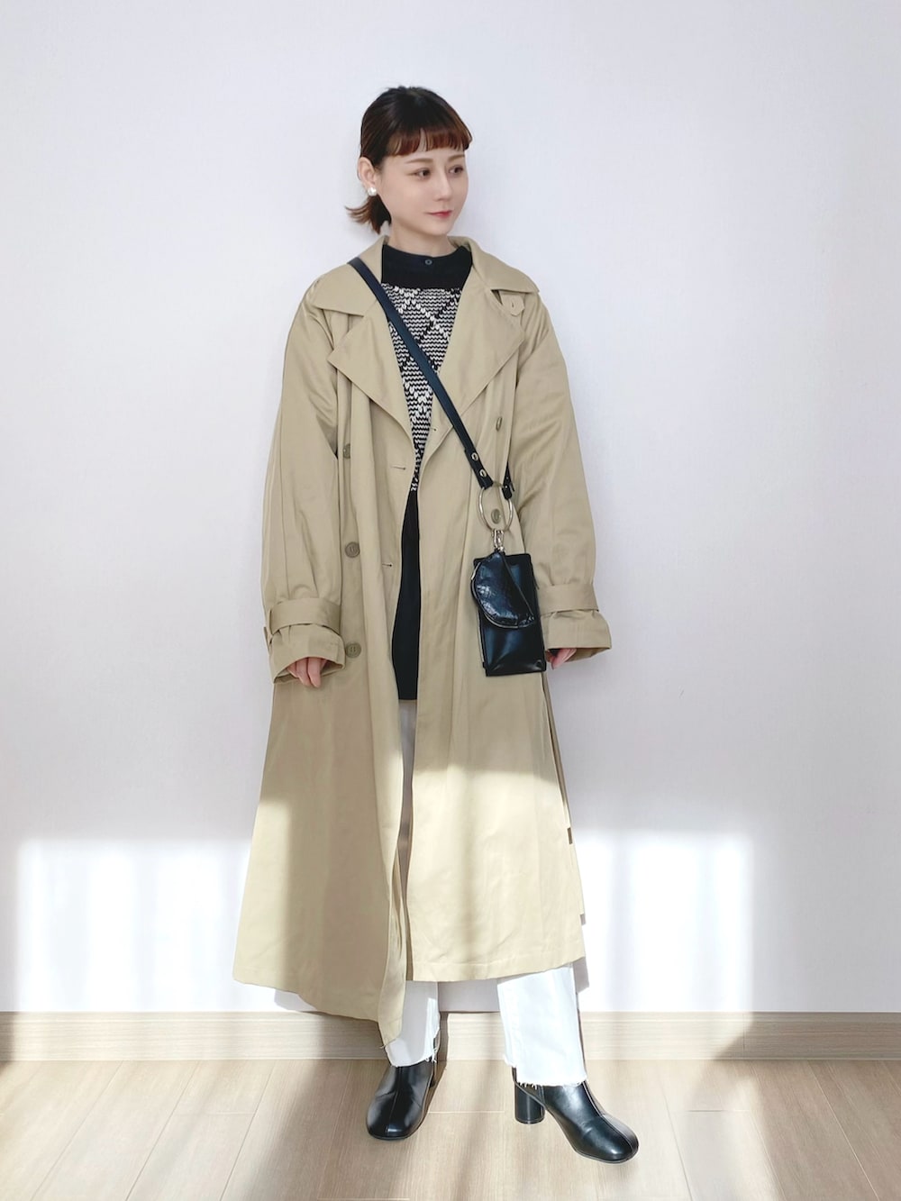 ベージュ系のミリタリージャケット、ブラック系のニット/セーター、ブラック系のショルダーバッグを着用したレディースの冬コーディネートの3枚目の写真