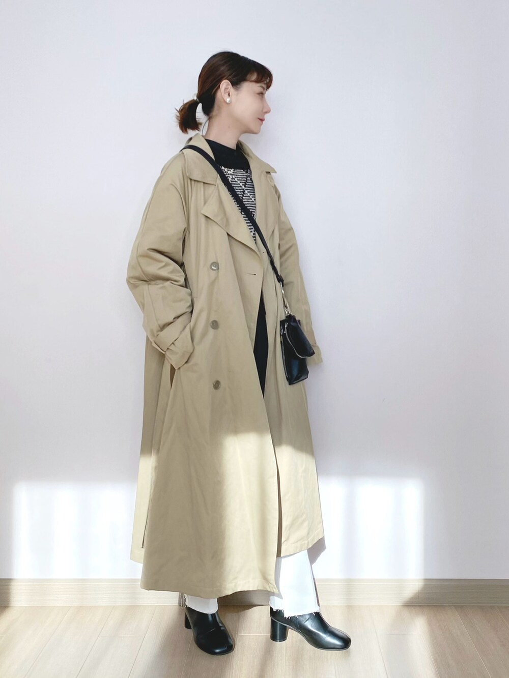 ベージュ系のミリタリージャケット、ブラック系のニット/セーター、ブラック系のショルダーバッグを着用したレディースの冬コーディネートの2枚目の写真