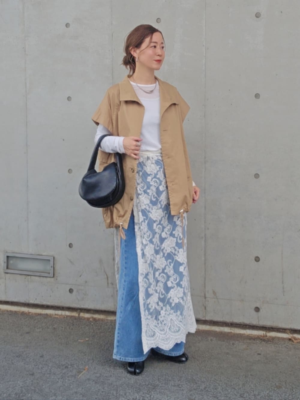 ホワイト系のスカート、ベージュ系のトレンチコート、ブルー系のデニムパンツを着用したレディースの春コーディネートの3枚目の写真