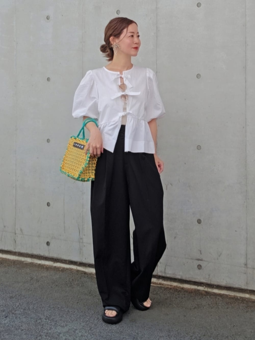 ホワイト系のシャツ/ブラウス、ブラック系のスラックス、ブラック系のシューズを着用したレディースの春コーディネートの3枚目の写真