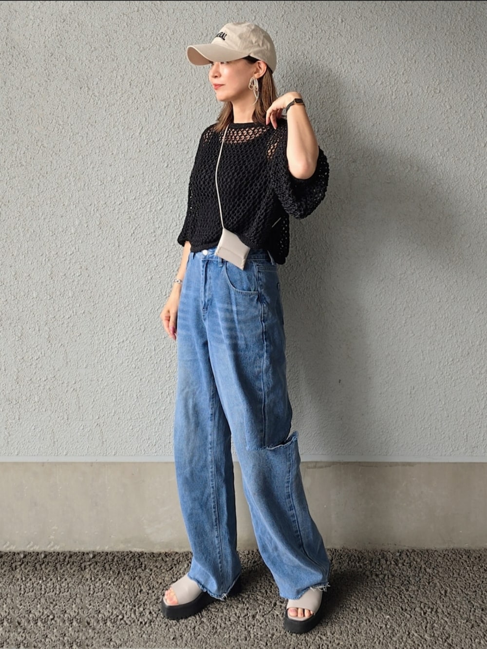 ブラック系のカーディガン/ボレロ、ブルー系のデニムパンツ、グレー系のサンダルを着用したレディースの春コーディネートの2枚目の写真