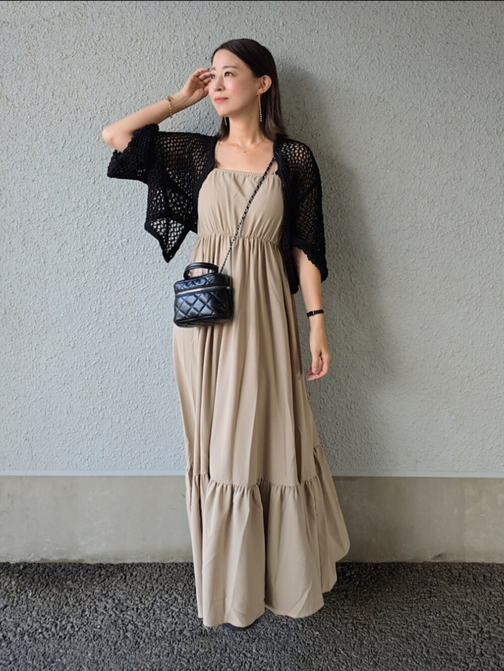 ベージュ系のワンピース/ドレス、ブラック系のカーディガン/ボレロ、ブラック系のサンダルを着用したレディースの夏コーディネートの2枚目の写真