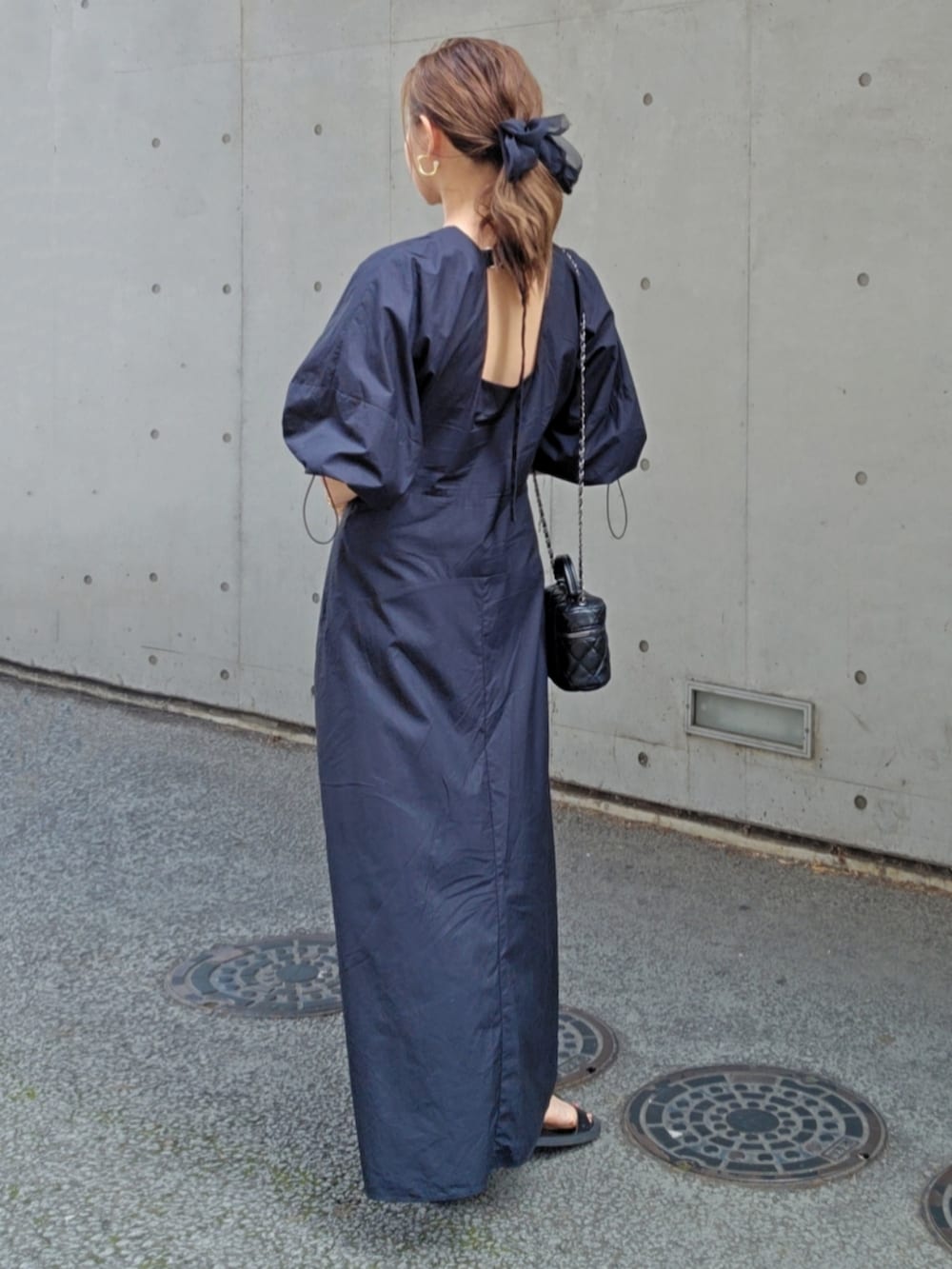 ブラック系のワンピース/ドレス、ブラック系のバッグ、ブラック系のサンダルを着用したレディースの夏コーディネートの3枚目の写真