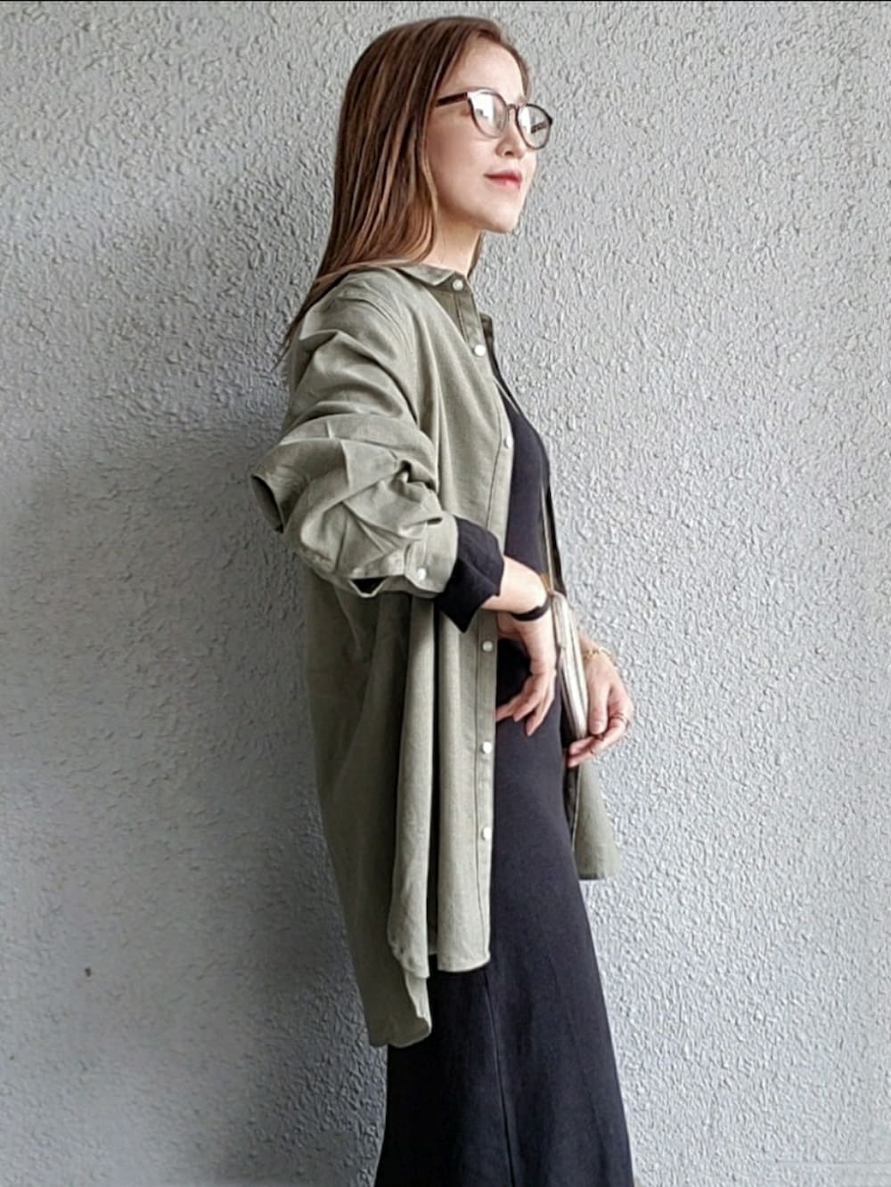 グリーン系のシャツ/ブラウス、ブラック系のワンピース、ベージュ系のスニーカーを着用したレディースの春コーディネートの3枚目の写真