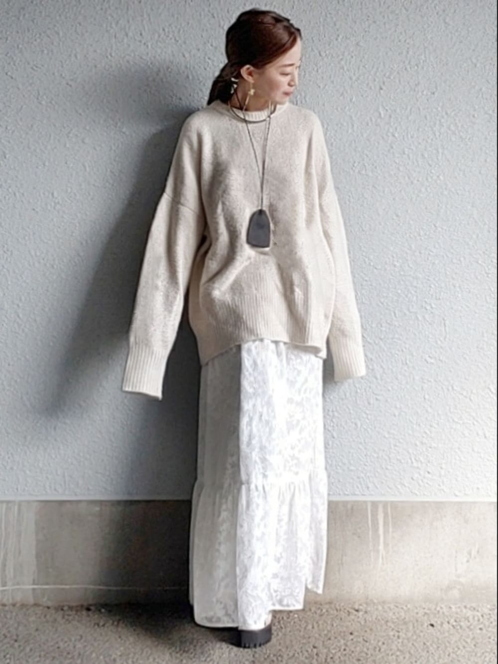 ホワイト系のニット/セーター、ホワイト系のスカート、グレー系のサンダルを着用したレディースの冬コーディネートの4枚目の写真