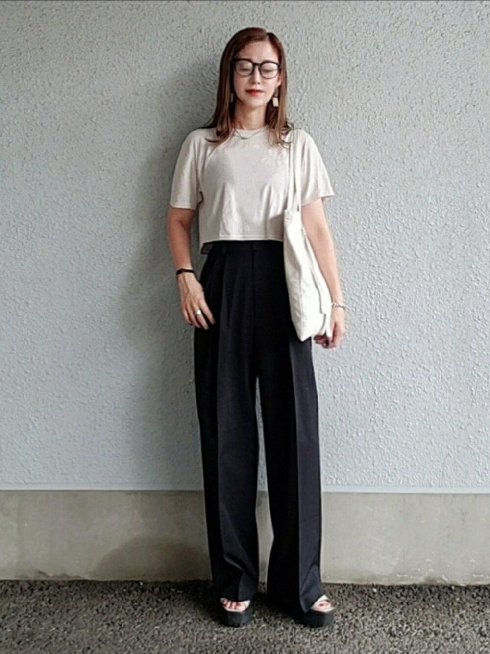 ブラック系のスラックス、グレー系のTシャツ/カットソー、ホワイト系のトートバッグを着用したレディースの夏コーディネートの2枚目の写真