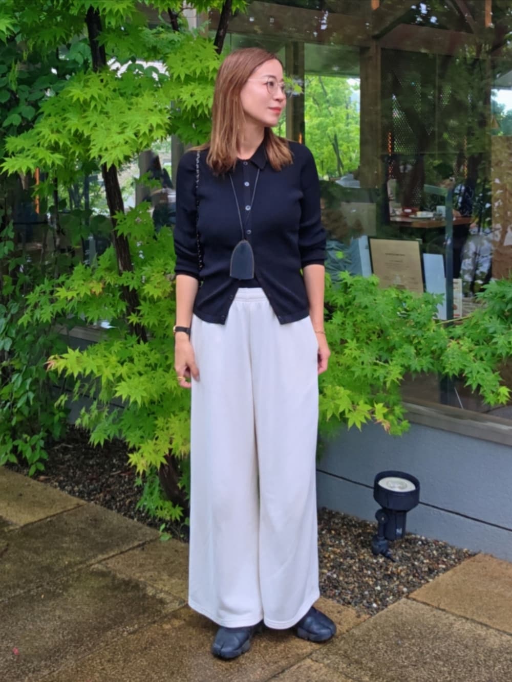 ホワイト系のパンツ、ブラック系のスニーカーを着用したレディースの夏コーディネートの3枚目の写真