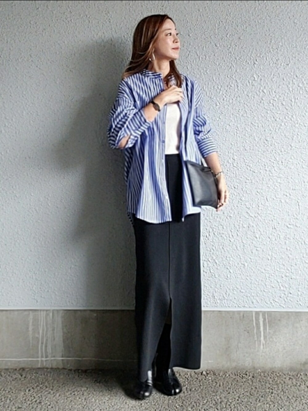 ブルー系のシャツ/ブラウス、ブラック系のスカート、ブラック系のブーツを着用したレディースの秋コーディネートの3枚目の写真