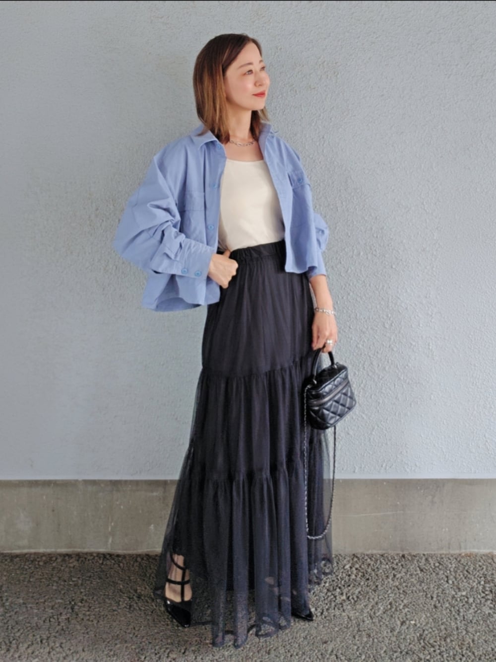 ホワイト系のキャミソール、ブルー系のシャツ/ブラウス、ブラック系のスカートを着用したレディースの春コーディネートの3枚目の写真