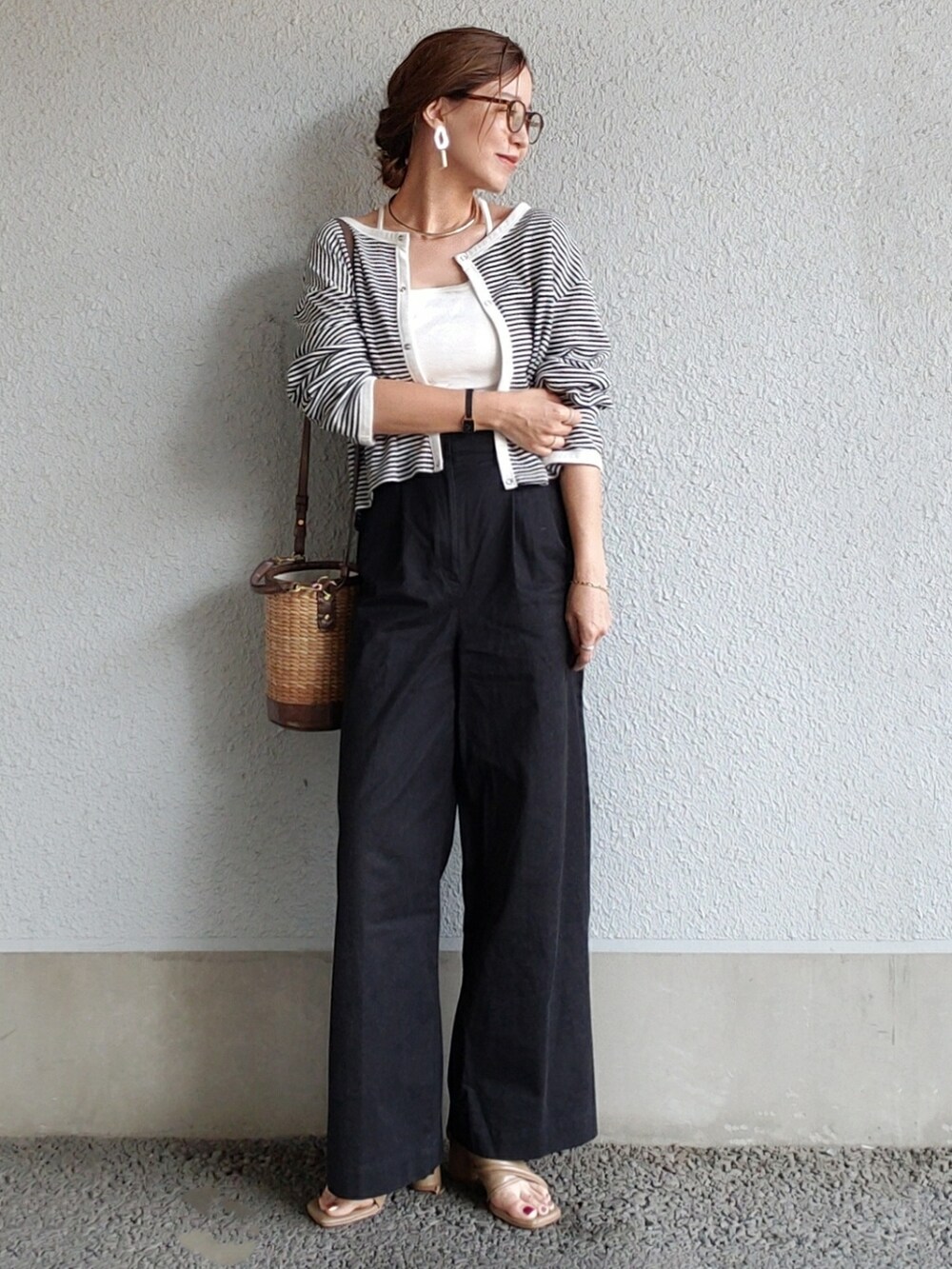 ホワイト系のキャミソール、ブラック系のチノパンツ、ブラウン系のサンダルを着用したレディースの春コーディネートの3枚目の写真