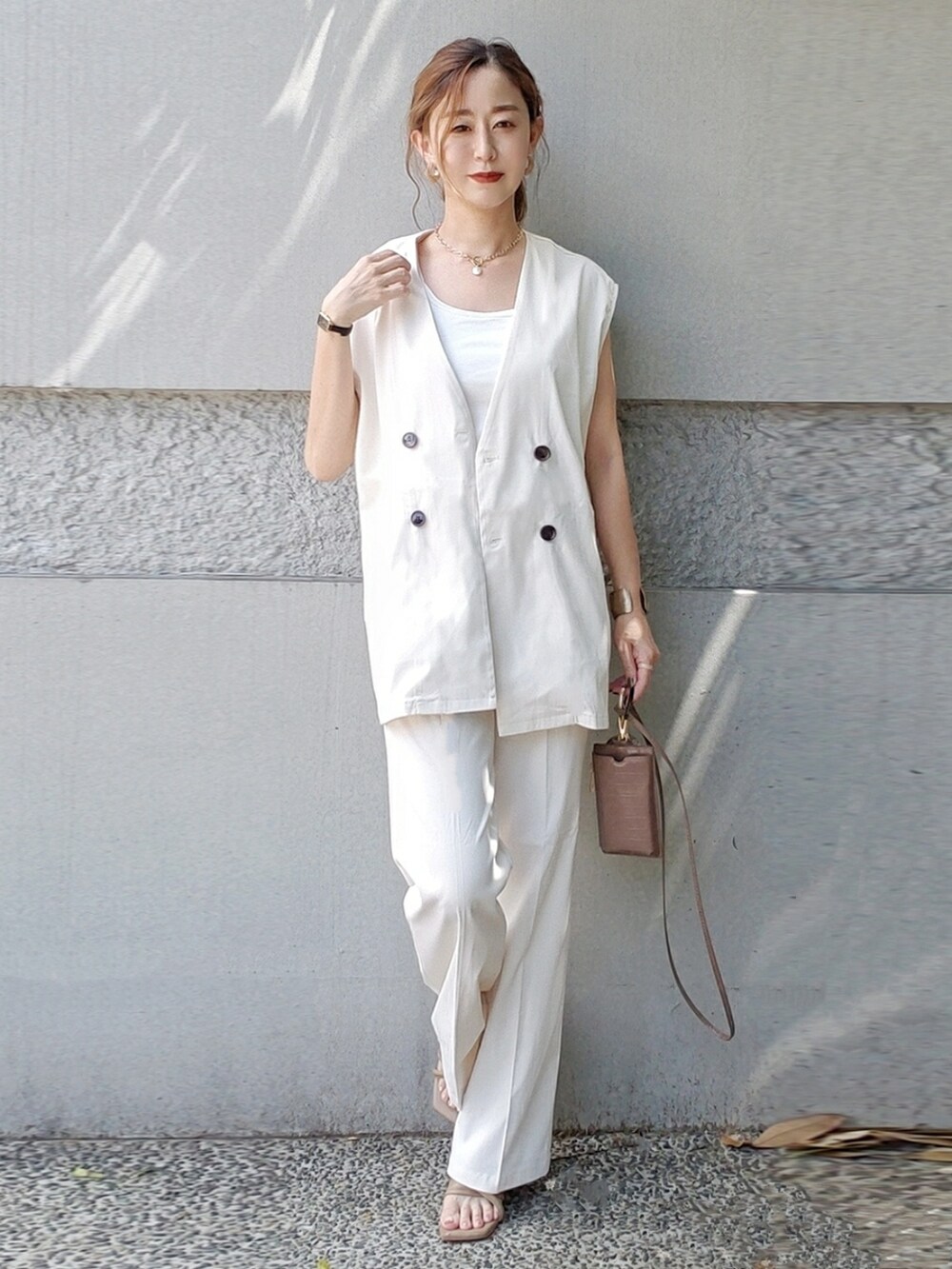 ホワイト系のフォーマルスーツ/小物、ブラウン系のサンダル、ブラック系の腕時計を着用したレディースの夏コーディネートの3枚目の写真