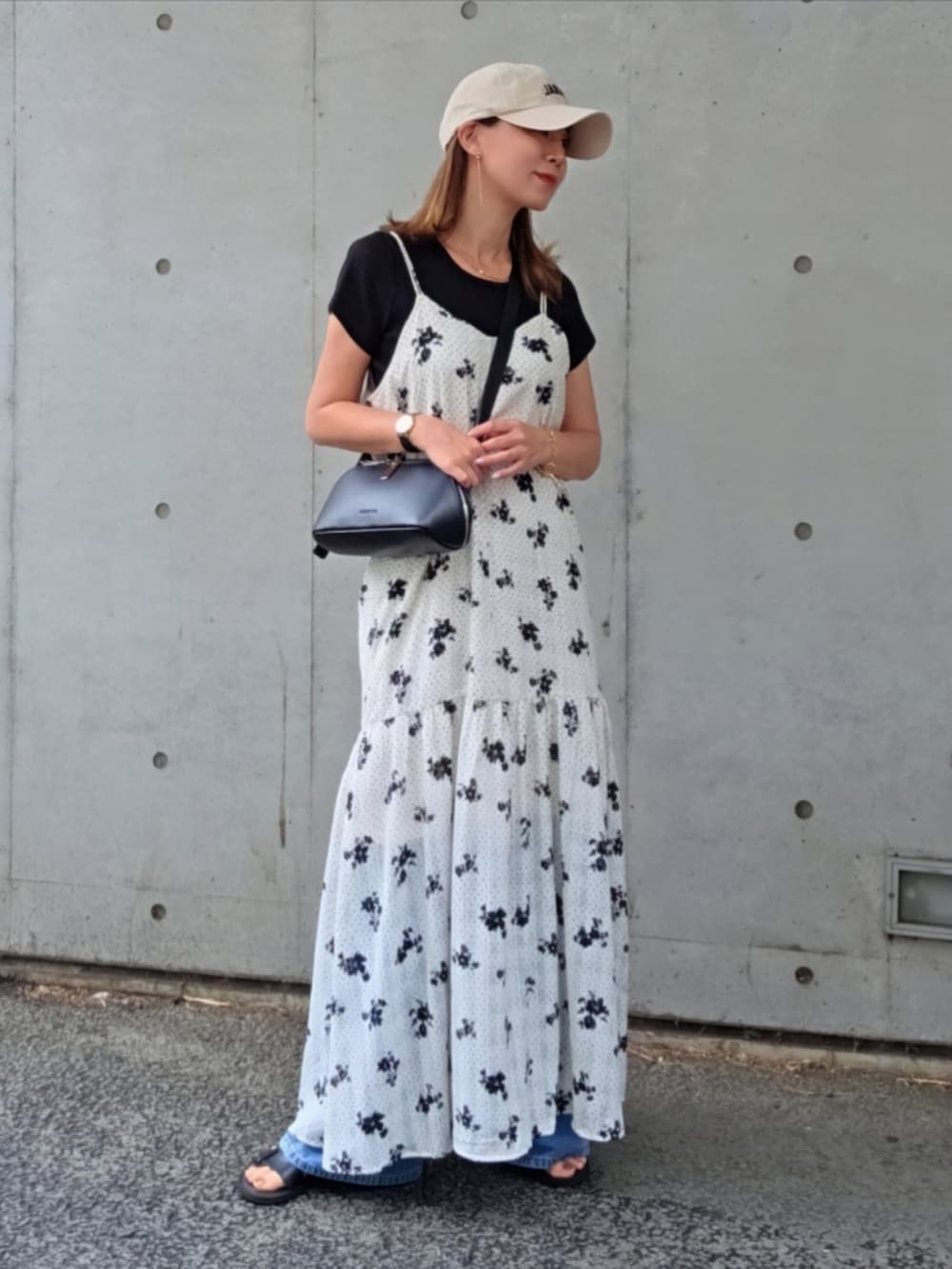 ホワイト系のワンピース、ブルー系のデニムパンツ、ブラック系のショルダーバッグを着用したレディースの夏コーディネートの2枚目の写真