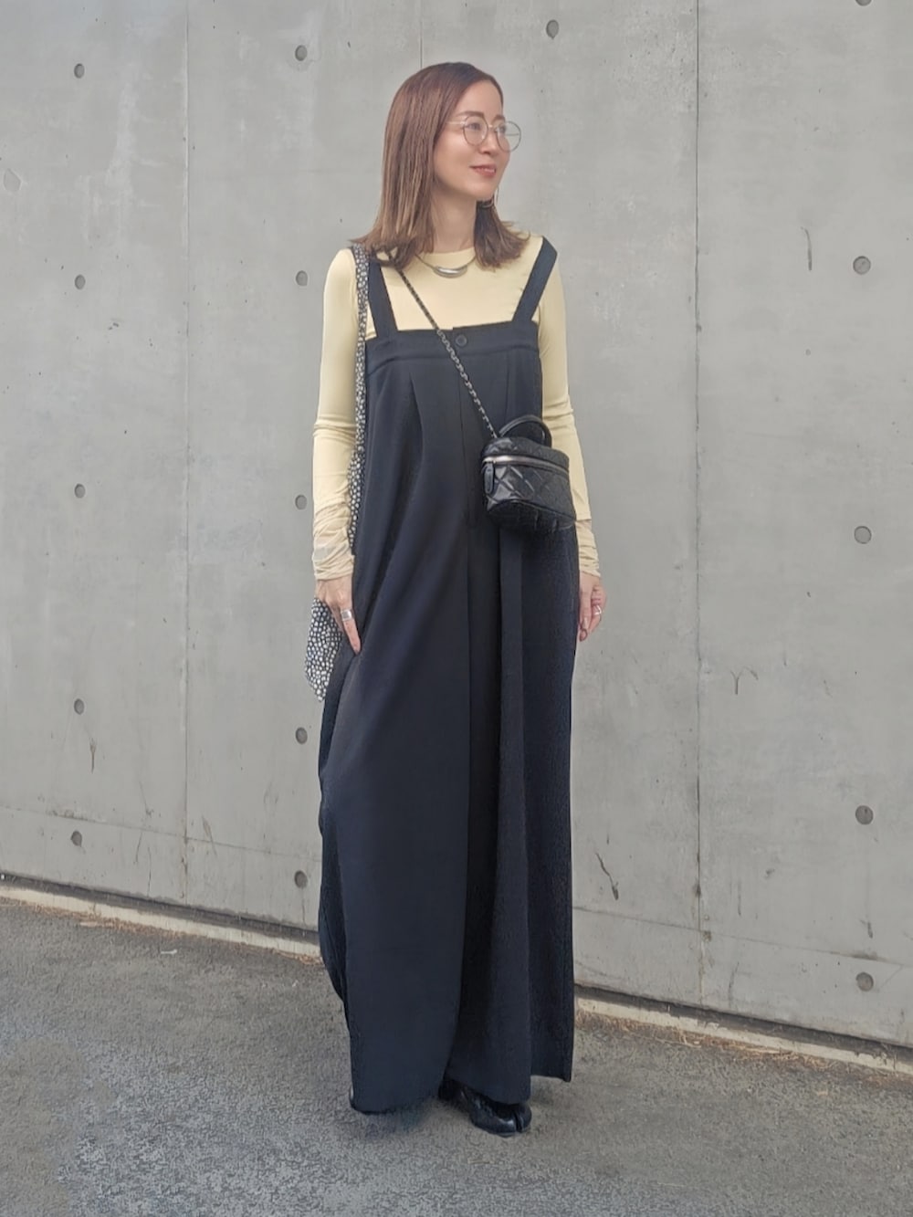 イエロー系のTシャツ/カットソー、ブラック系のバッグ、ブラック系のサロペット/オーバーオールを着用したレディースの春コーディネートの2枚目の写真