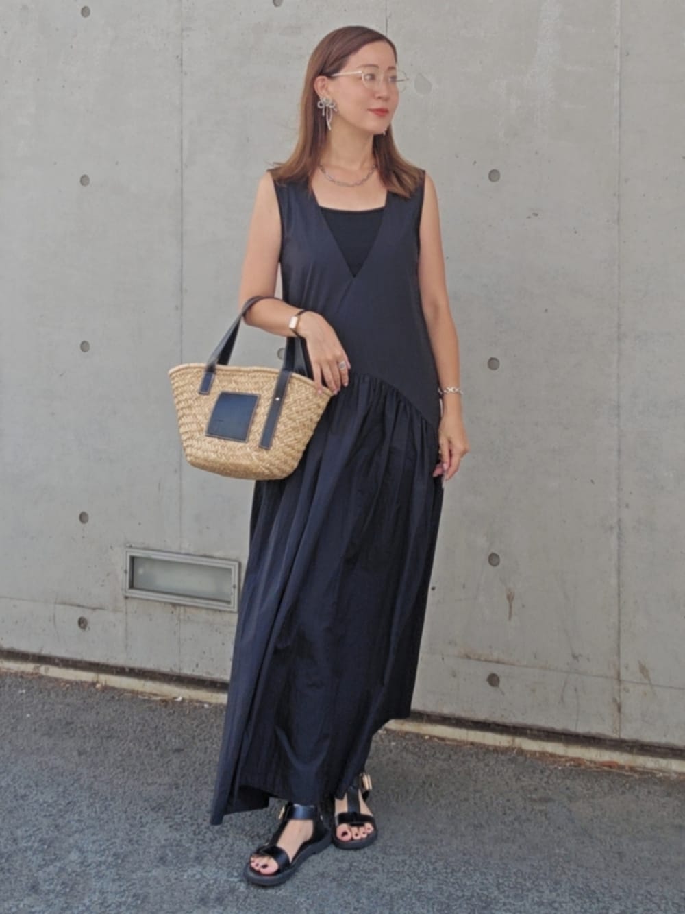 ブラック系のワンピース、ブラック系のかごバッグ、ブラック系のサンダルを着用したレディースの夏コーディネートの2枚目の写真