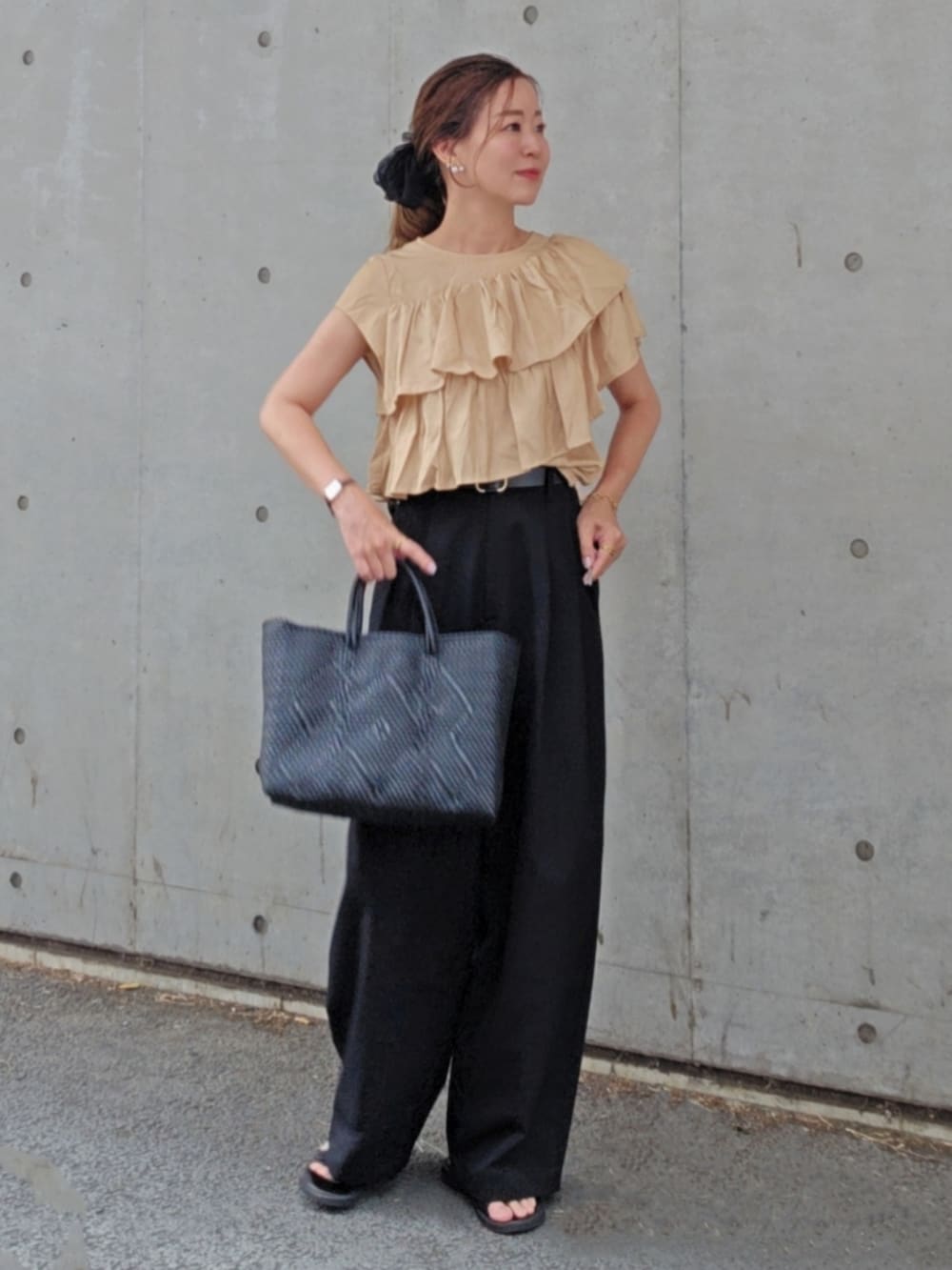 ベージュ系のシャツ/ブラウス、ブラック系のスラックス、ブラック系のサンダルを着用したレディースの夏コーディネートの2枚目の写真