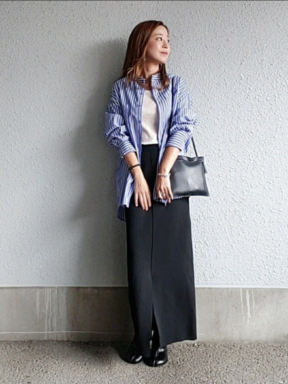 ブルー系のシャツ/ブラウス、ブラック系のスカート、ブラック系のブーツを着用したレディースの秋コーディネートの2枚目の写真