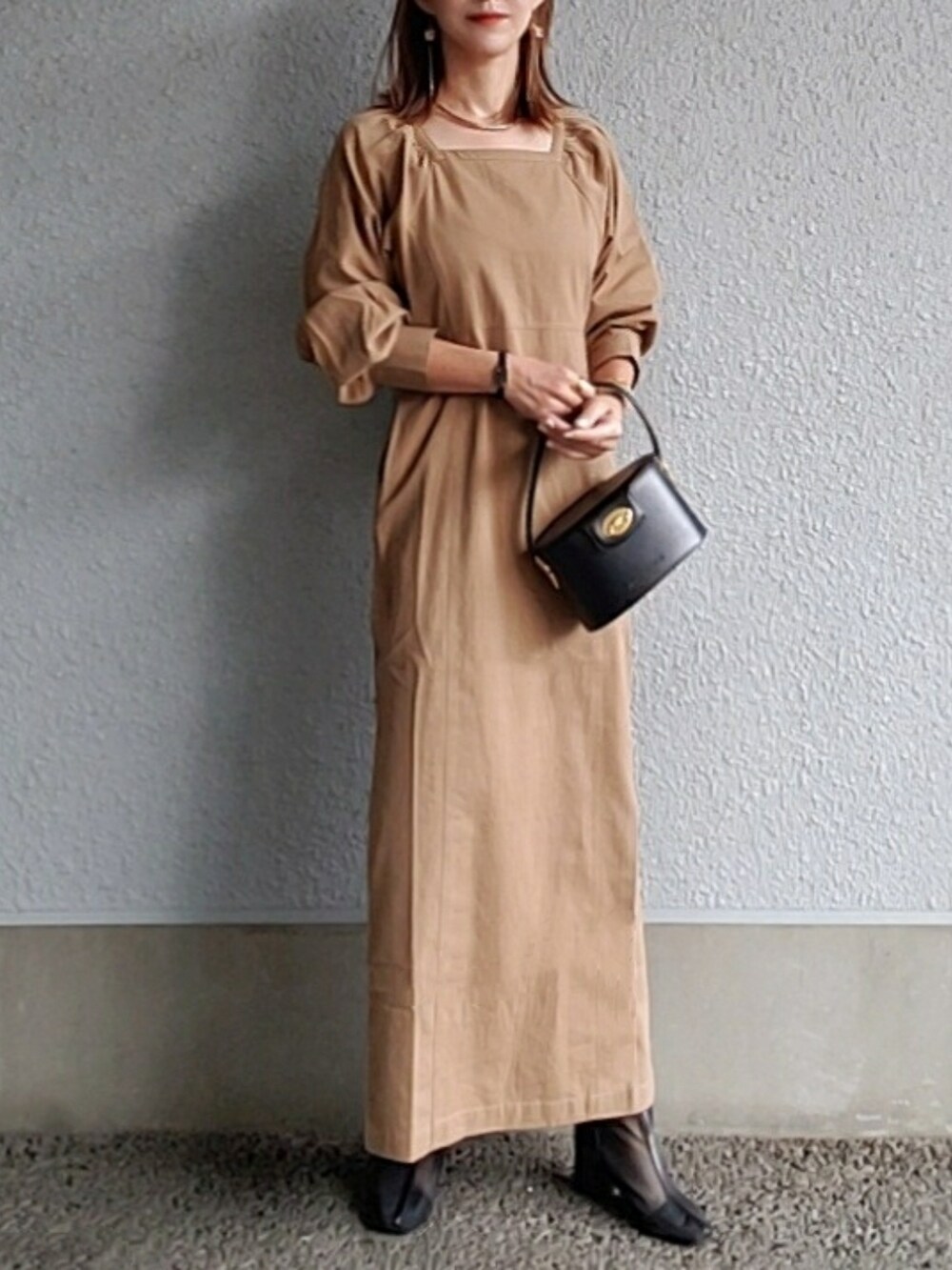 ブラウン系のワンピース、ブラック系のブーツ、ゴールド系のブレスレットを着用したレディースの秋コーディネートの2枚目の写真