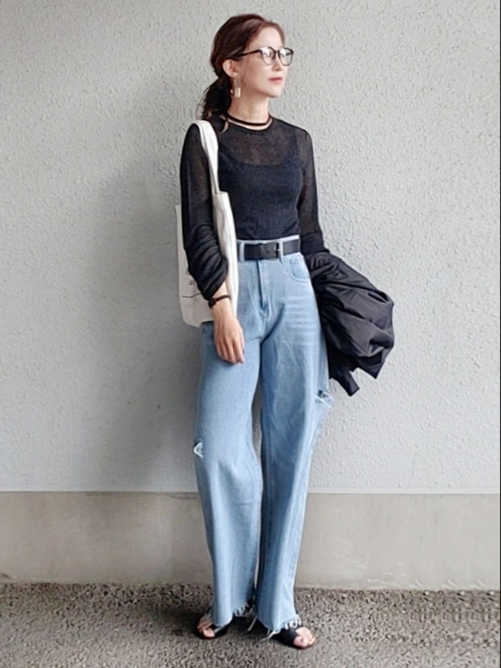 グレー系のニット/セーター、ブルー系のデニムパンツ、ブラック系のサンダルを着用したレディースの春コーディネートの4枚目の写真