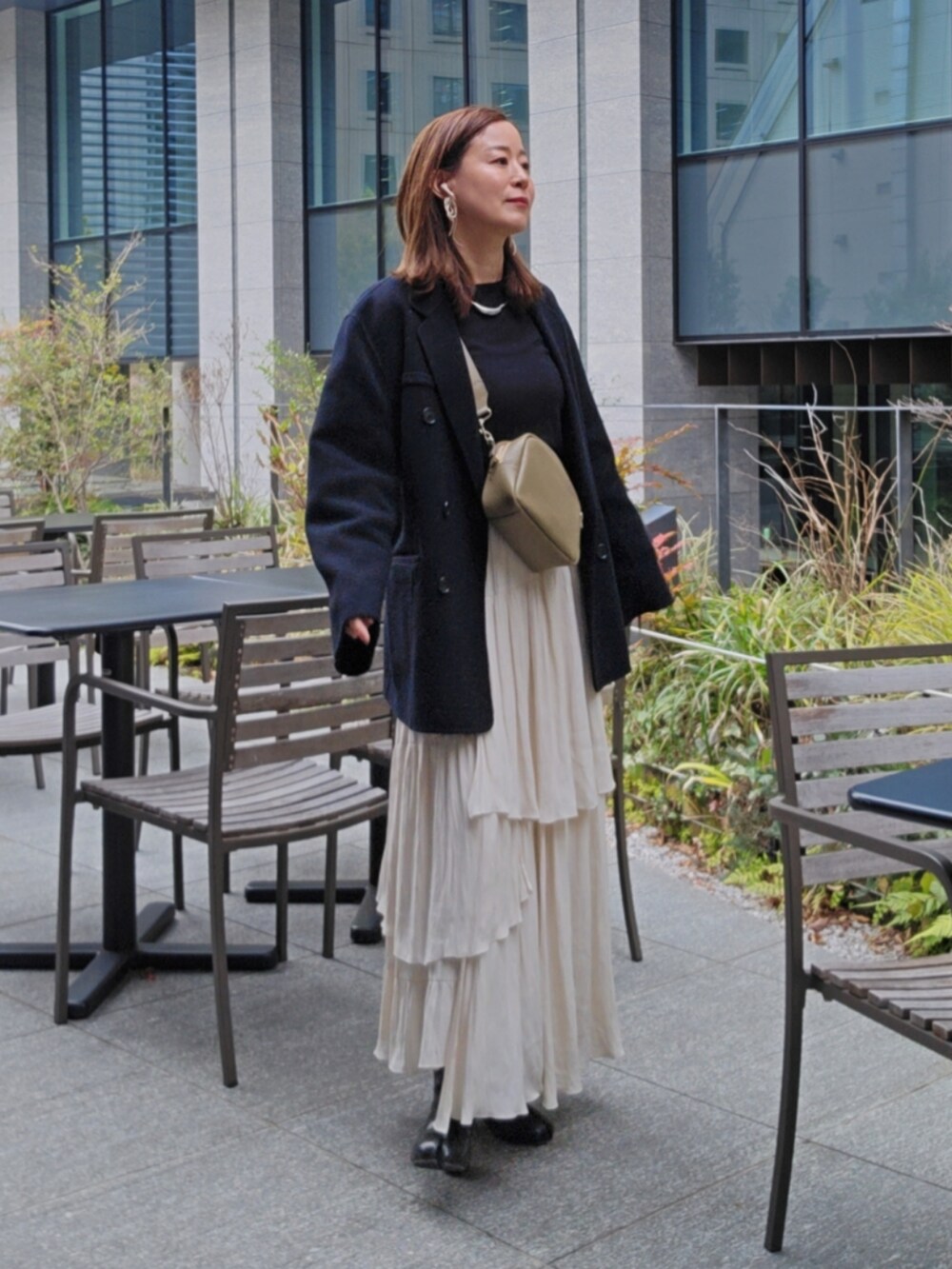 ブラック系のTシャツ/カットソー、ホワイト系のスカート、ブラック系のブーツを着用したレディースの春コーディネートの2枚目の写真