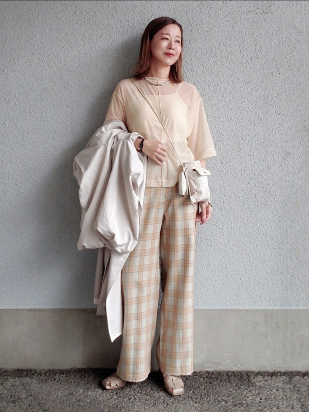 ベージュ系のその他パンツ、グレー系のサンダル、ベージュ系のTシャツ/カットソーを着用したレディースの春コーディネートの4枚目の写真