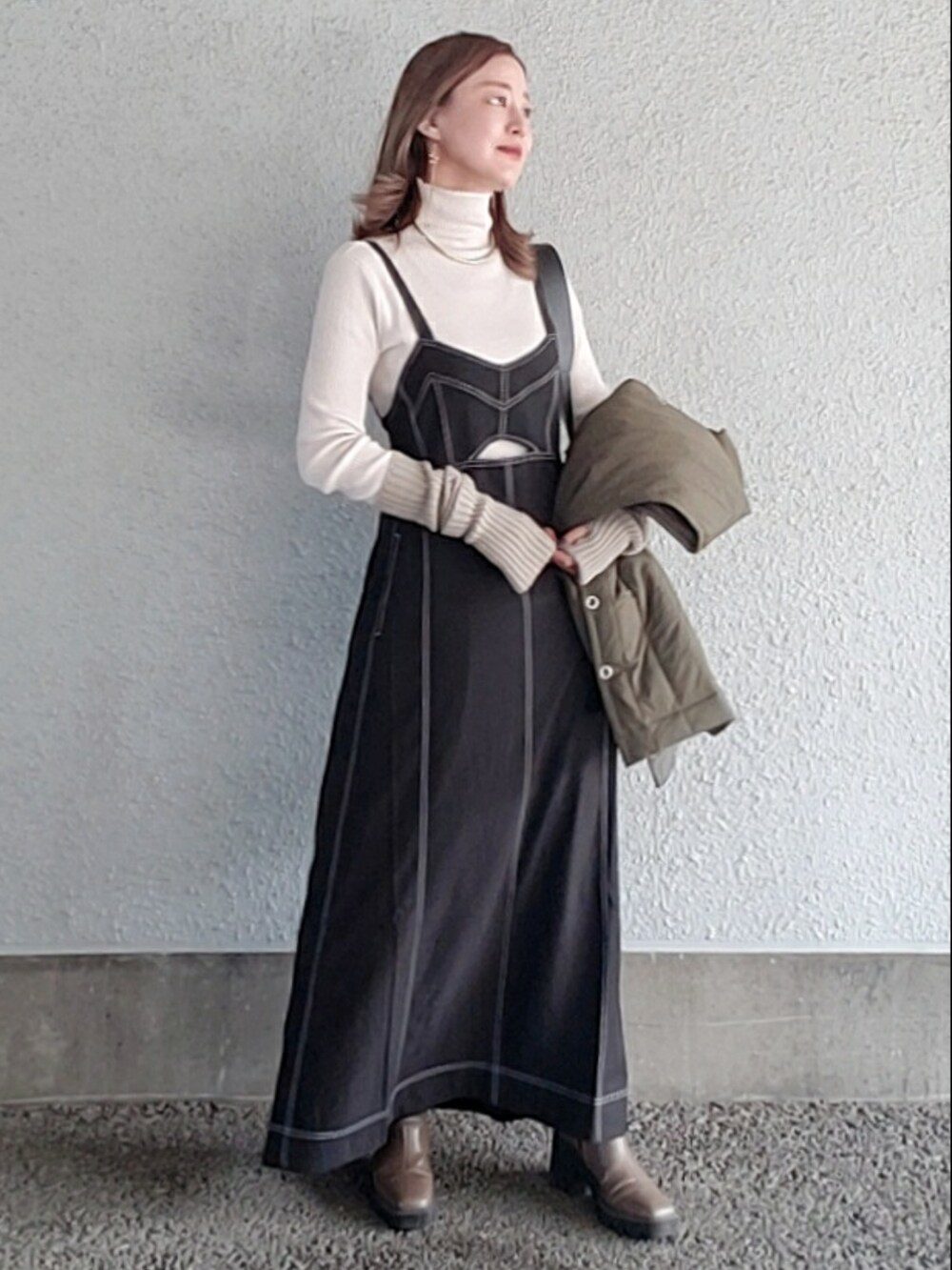 ホワイト系のニット/セーター、グリーン系のダウンベスト、ベージュ系のブーツを着用したレディースの冬コーディネートの2枚目の写真