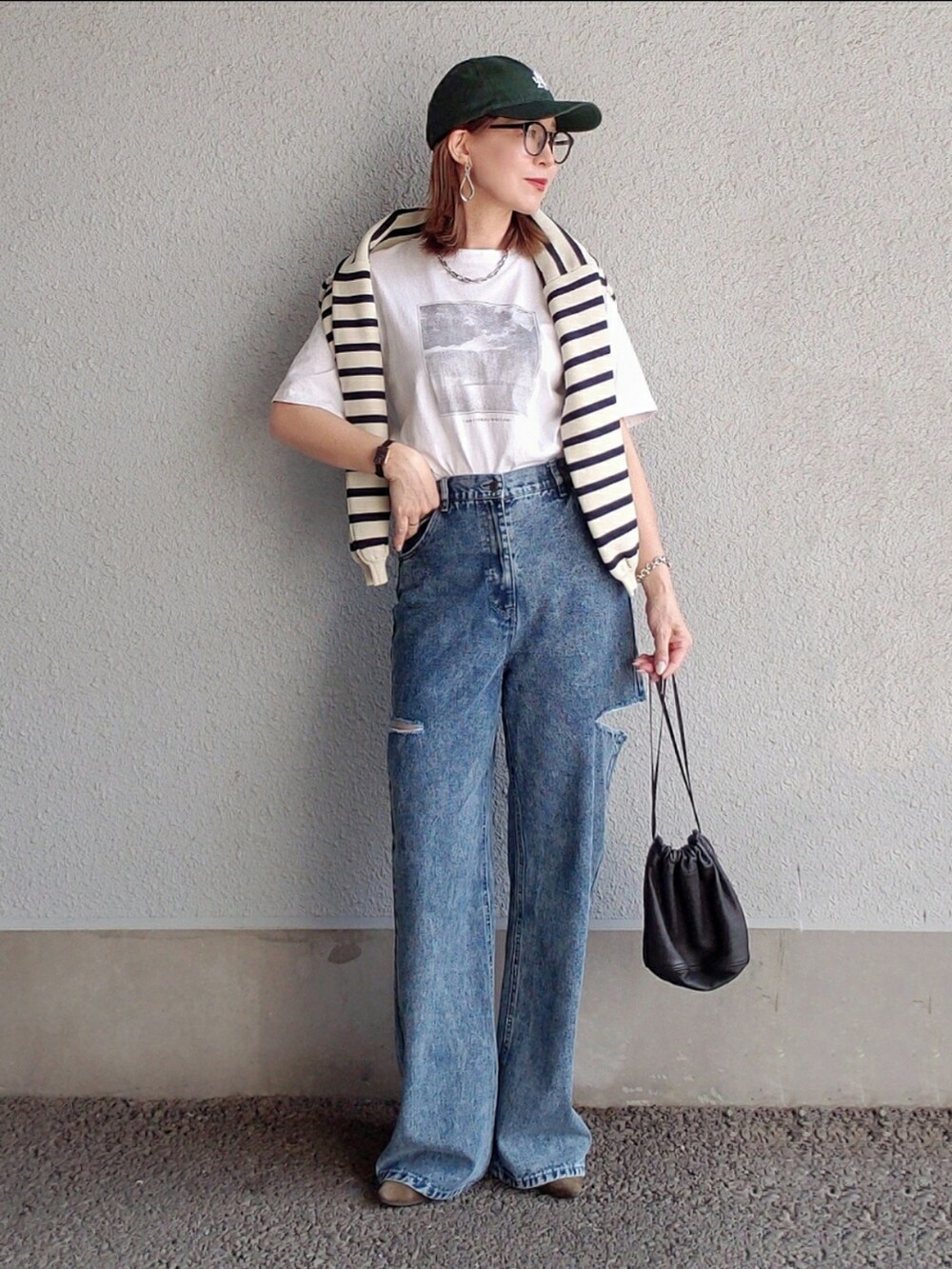 ブルー系のデニムパンツ、ホワイト系のTシャツ/カットソー、グレー系のカーディガン/ボレロを着用したレディースの春コーディネートの3枚目の写真