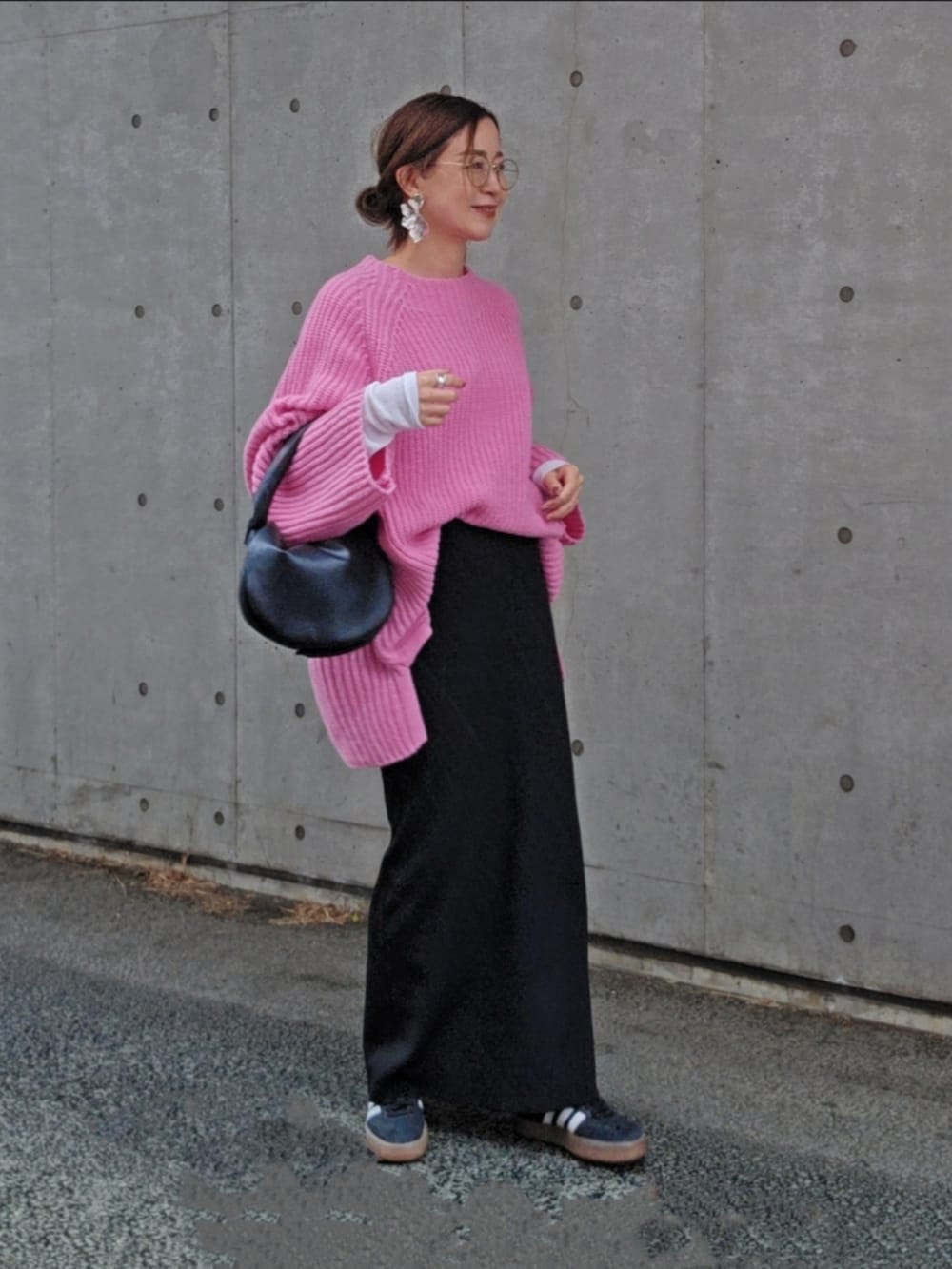 ピンク系のニット/セーター、ブラック系のスニーカー、ブラック系のスカートを着用したレディースの春コーディネートの2枚目の写真