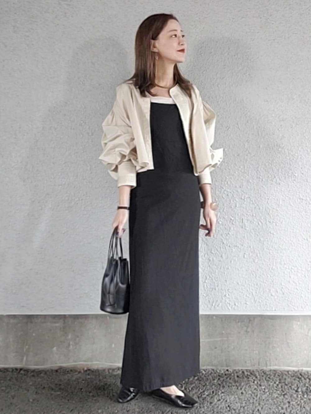 ブラック系のワンピース、ブラック系のハンドバッグ、ホワイト系のシャツ/ブラウスを着用したレディースの春コーディネートの3枚目の写真