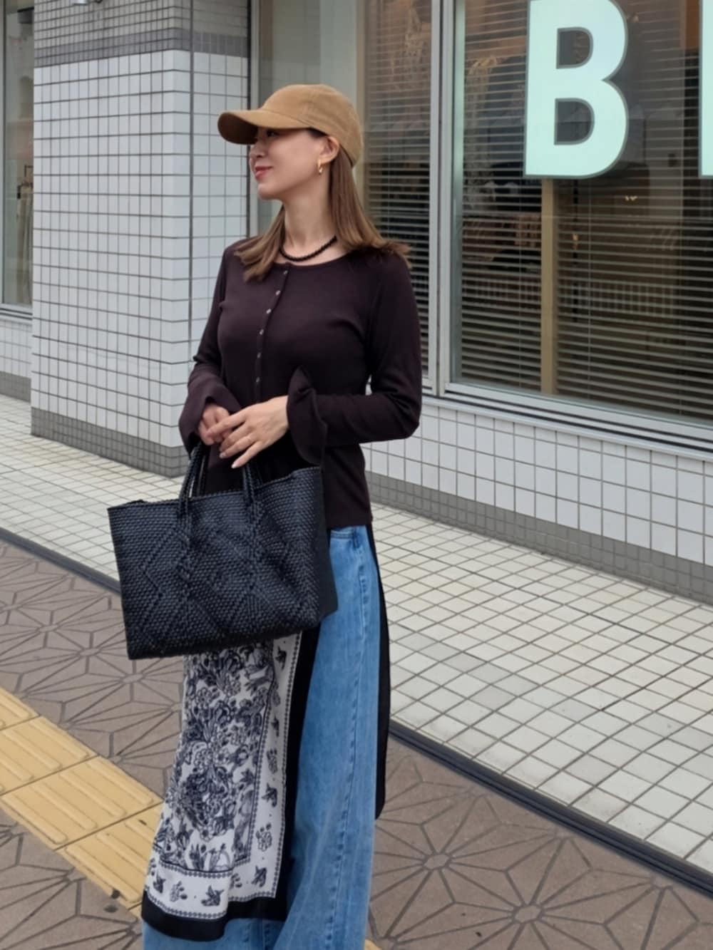 ブラウン系のカーディガン/ボレロ、ブルー系のデニムパンツ、ブラック系のバンダナ/スカーフを着用したレディースの秋コーディネートの3枚目の写真