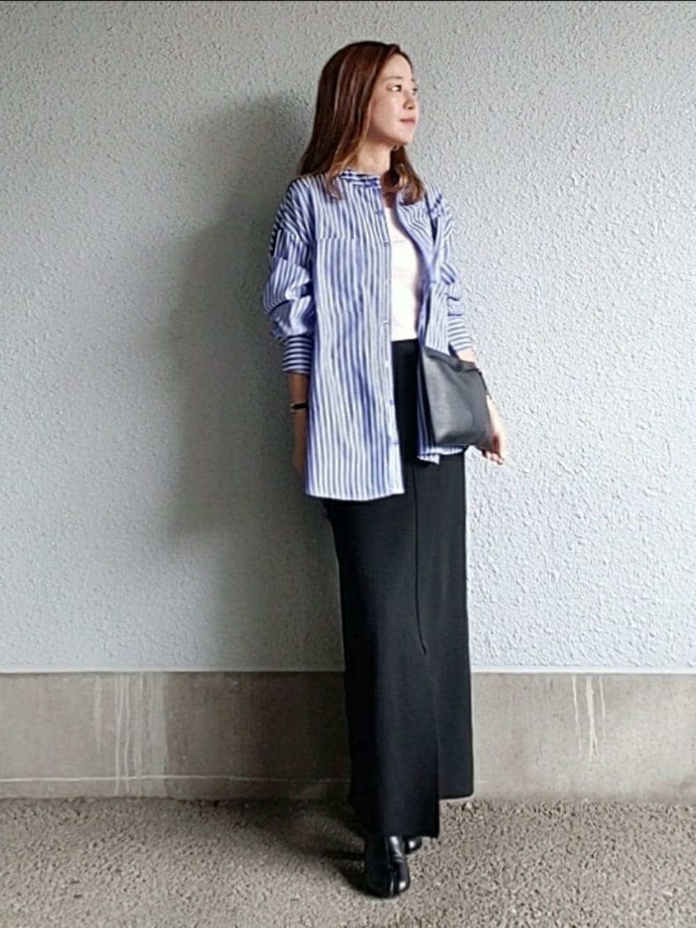 ブルー系のシャツ/ブラウス、ブラック系のスカート、ブラック系のブーツを着用したレディースの秋コーディネートの4枚目の写真