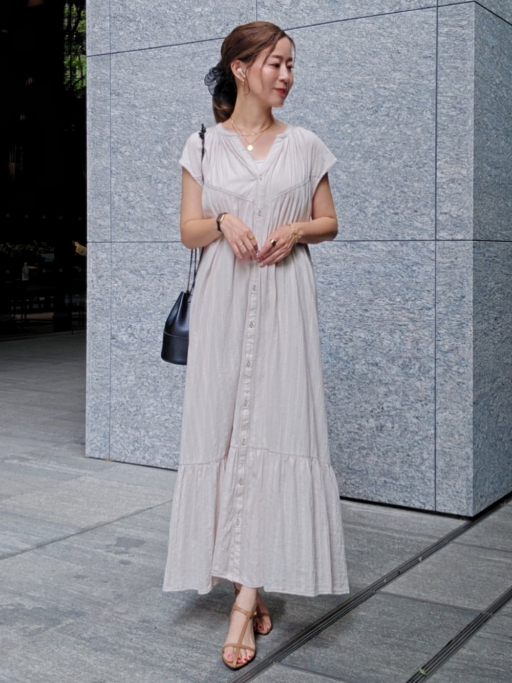 ベージュ系のワンピース、ブラウン系のサンダルを着用したレディースの夏コーディネートの3枚目の写真